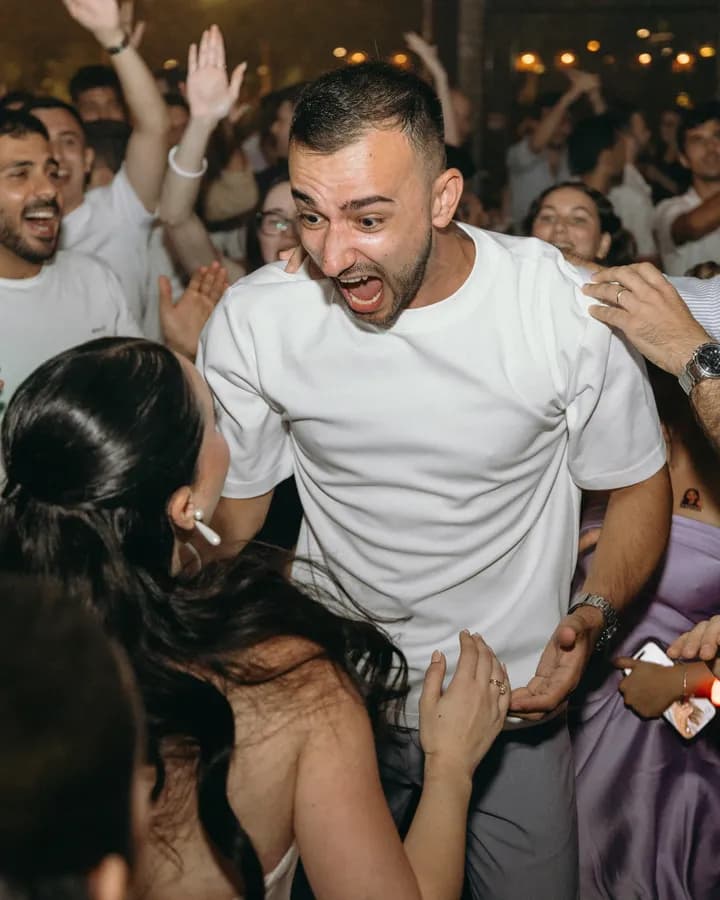 A guest cheering surrounded by friends